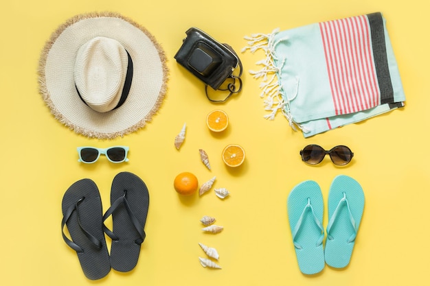 Beach accessories for two straw beach sunhattowel sun glasses on yellow Summer concept and tropical vacations