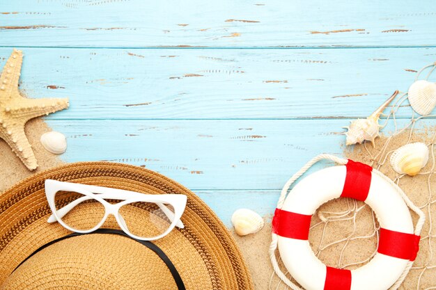 Beach accessories with sand on blue background