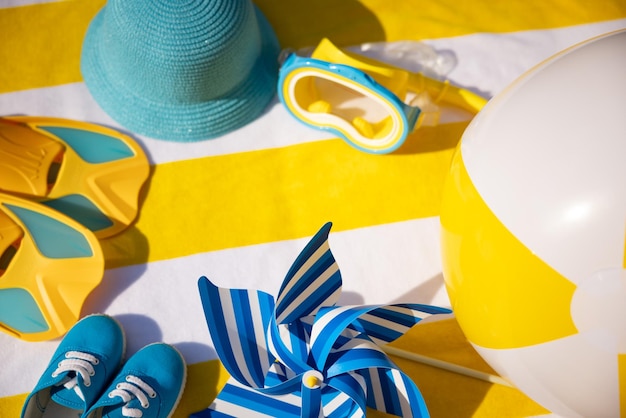 Beach accessories on yellow striped towel Summer vacation concept