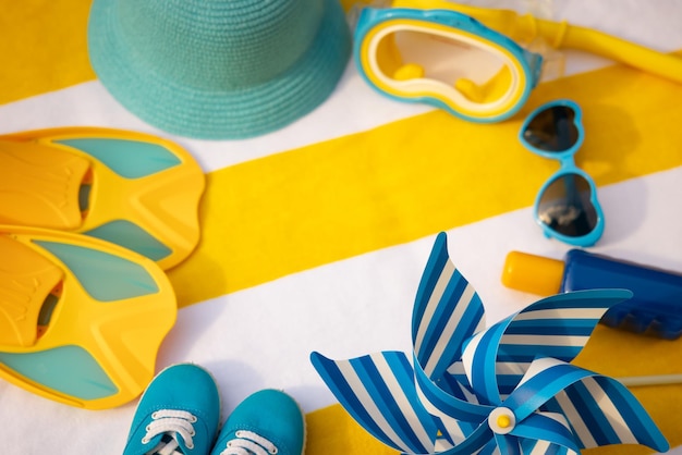 Beach accessories on yellow striped towel Summer vacation concept