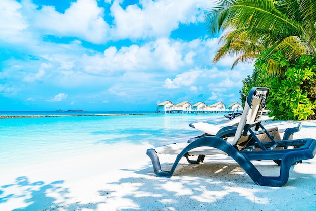 beach chair with tropical Maldives resort hotel island and sea background