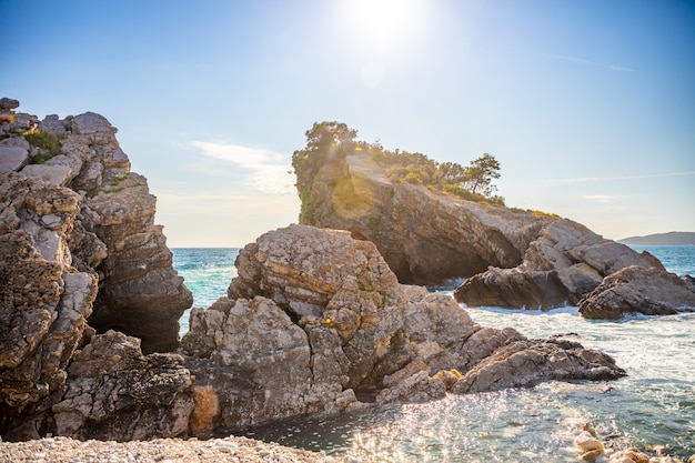 The beach and the cliffs on the island of st nicholas in budva montenegro paradise beach on an islan...