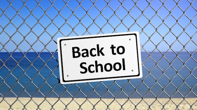 Beach enclosed by fence with sign Back to School