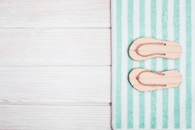 Beach flip-flops and striped cotton towel