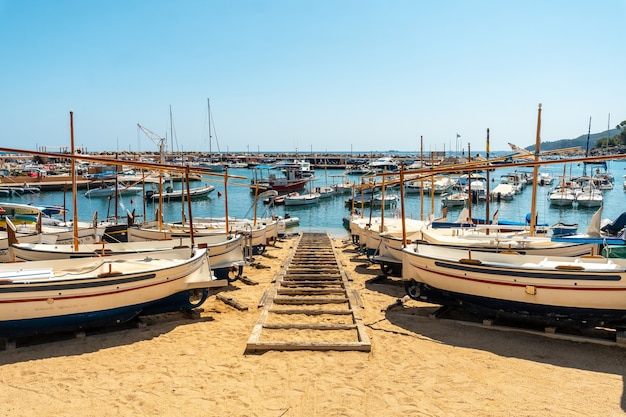 Photo beach full of boats in llafranc, girona on the costa brava of catalonia in the mediterranean