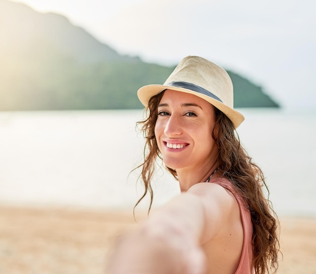 The beach is calling Portrait of a young woman on holiday leading her unidentifiable boyfriend by the hand