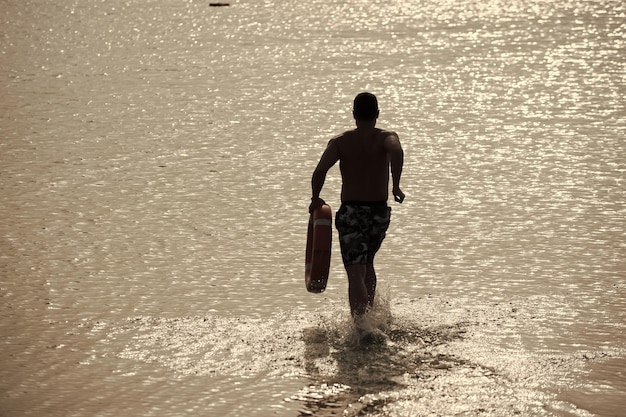 Beach lifeguard Man back silhouette with red life ring