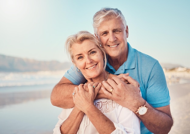 Beach love and portrait of senior couple hugging in nature holiday or romantic outdoor date together at the ocean sea or sand Happy smile and people in a hug embrace or happiness on anniversary