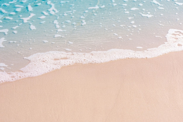 The beach and sand with the blue water and foaming wave in the tropical beach in Thailand