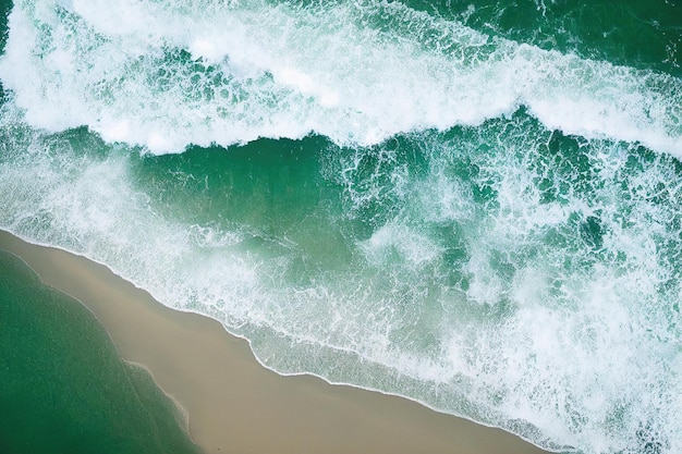 Beach and waves from above Aerial view of a blue ocean Top view of the drone