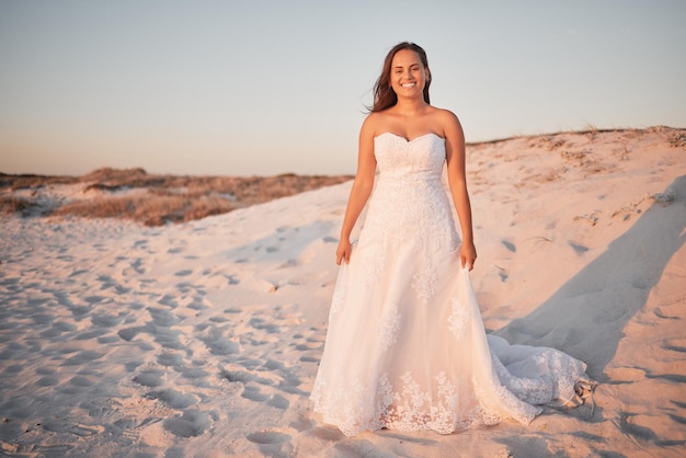 Beach wedding bride and happy woman in a white dress while standing in sand and sun enjoying her special day at a tropical and romantic destination Portrait of Columbia female by sea for honeymoon