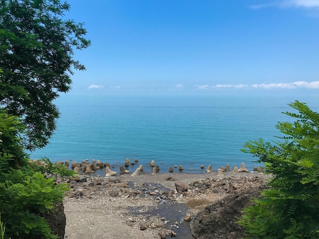 A beach with a blue sky and the water in the background