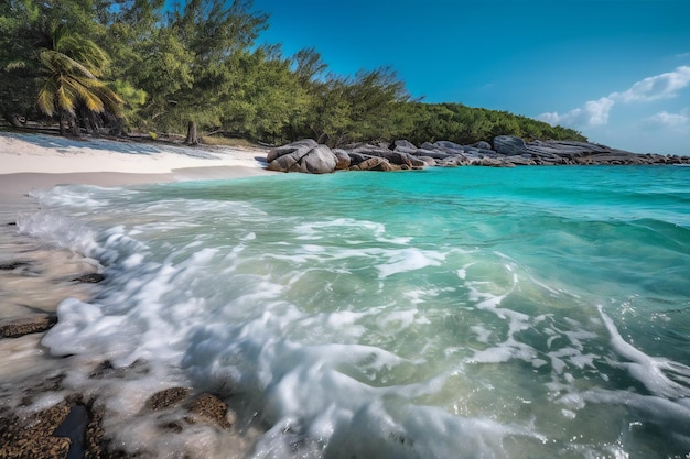 A beach with a blue water and a white sand beach with a rocky shoreline and trees in the background