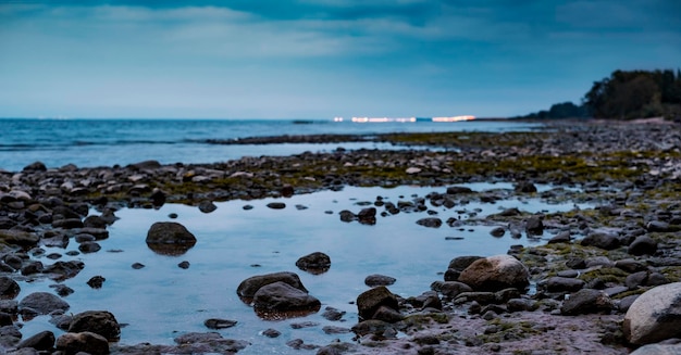 A beach with a boat on it and a light in the sky