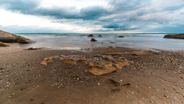 A beach with a cloudy sky in the background