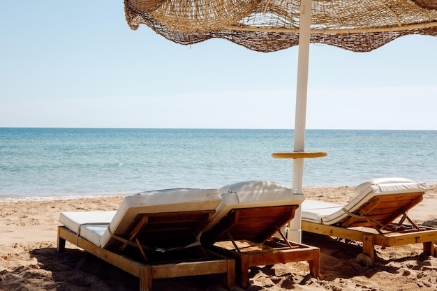 A beach with a parasol and a beach chair on it