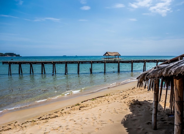 A beach with a pier and a hut on it