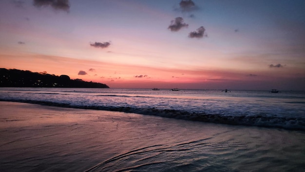 A beach with a pink sky and a beach in the background