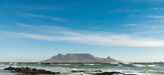 A beach with a table mountain in the background