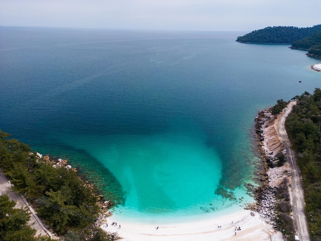 The beach with white marble pebbles and turquoise sea on the Greek island of Thassos Aerial view The contrast of the pristine white pebbles against the vivid blue sea creates a mesmerizing view