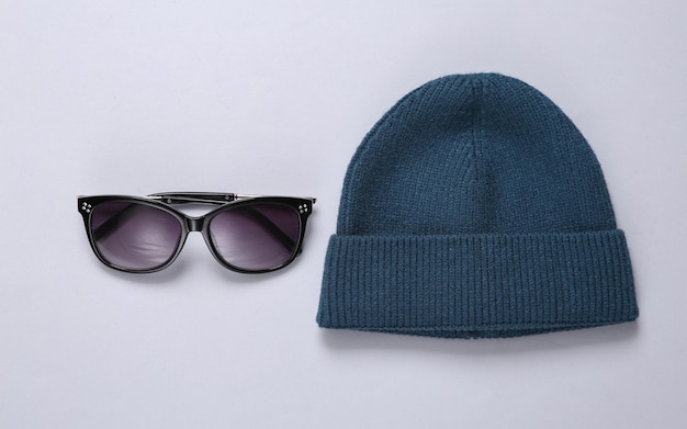 Beanie and sunglasses on gray background Youth concept Top view