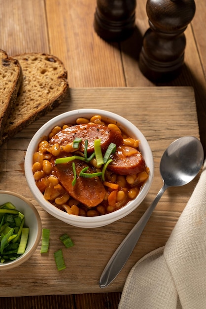 Beans with sausage and tomato sauce in bowl Beans stew homemade rustic english food Rustic wooden background