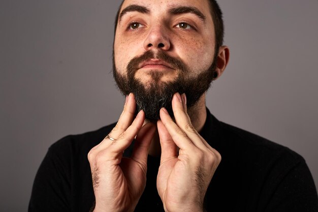 Beard care Closeup of male face and pipette with a oil for a beard growth