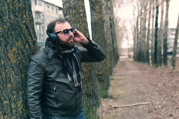 Beard man in park with headphon