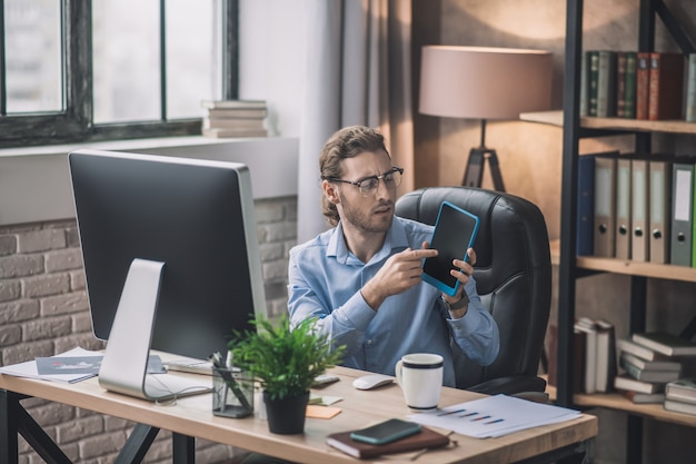 Bearded businessman in blue shirt working under project