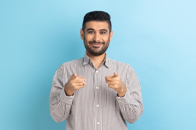 Bearded businessman pointing fingers at camera and looking with toothy smile believes in you