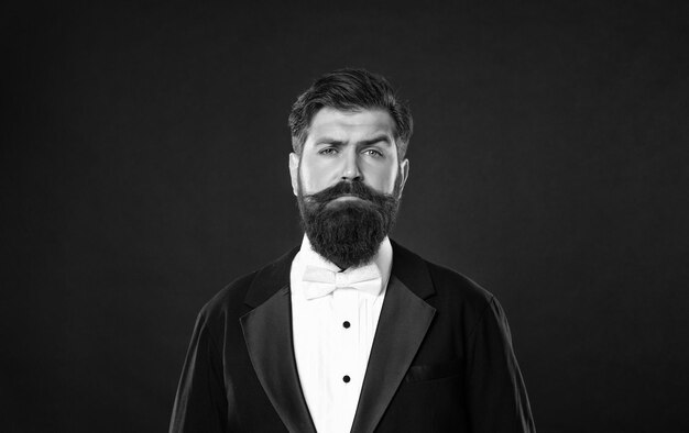 Photo bearded businessman in tuxedo on black background menswear