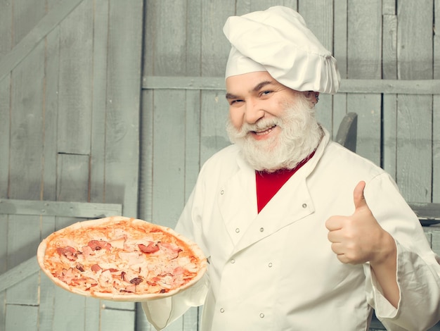 Bearded cook with pizza