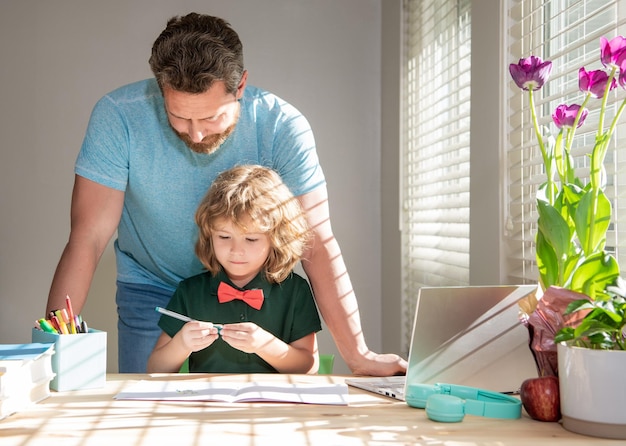 Bearded daddy writing school homework with his child son in classroom modern education