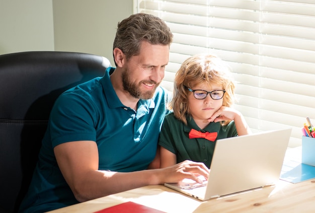 Bearded father and son in glasses use computer at home family blog nerd boy do homework