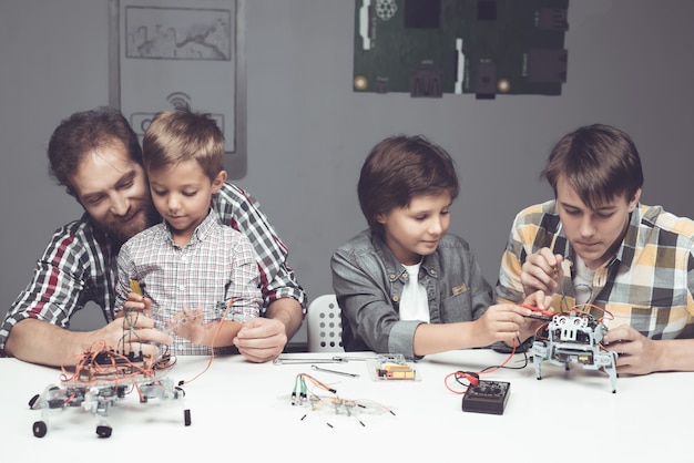 Bearded Father and Sons Constructing Robot at Home