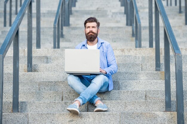 Bearded freelancer man has online laptop communication outdoor freelancer man