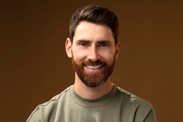 Bearded handsome man in casual style looking at the camera and smiling while posing