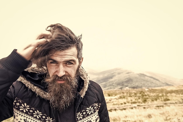 Bearded handsome serious man on mountain top