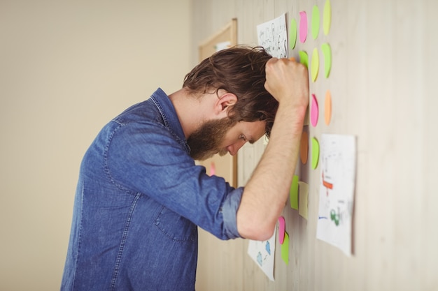 Bearded hipster frustrated at brainstorm wall 