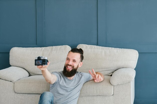 Bearded hipster man taking a selfie using photo camera idle leisure and relaxed carefree lifestyle modern social trends concept