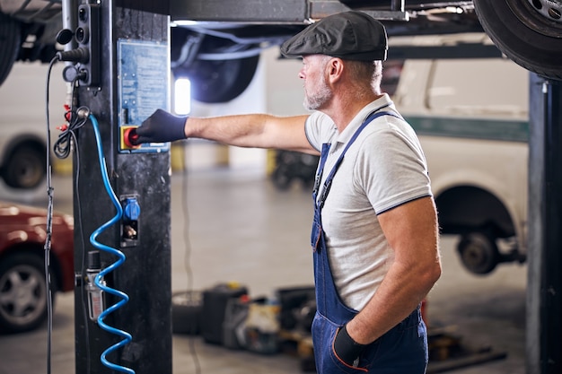 Bearded male technician working in auto repair shop