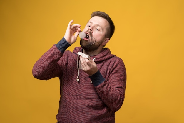 Bearded man breathes on lenses of his glasses he is going to clean them of dust using special cloth