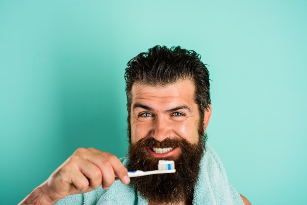 Bearded man brushing teeth. Tooth brush. Tooth paste. Morning treatments. Morning routine. Health care. Dental hygiene.