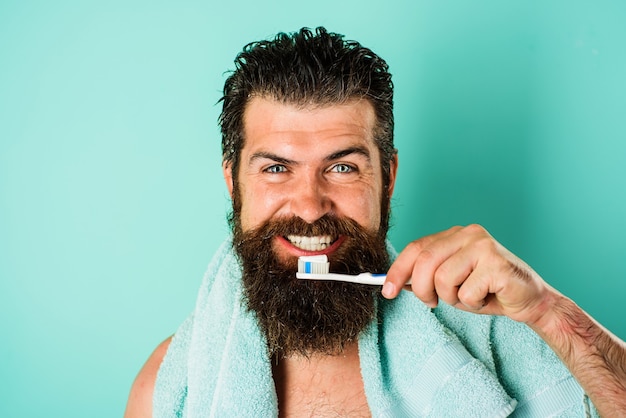 Bearded man brushing teeth with Toothbrush and Toothpaste. Dental hygiene. Morning treatments.