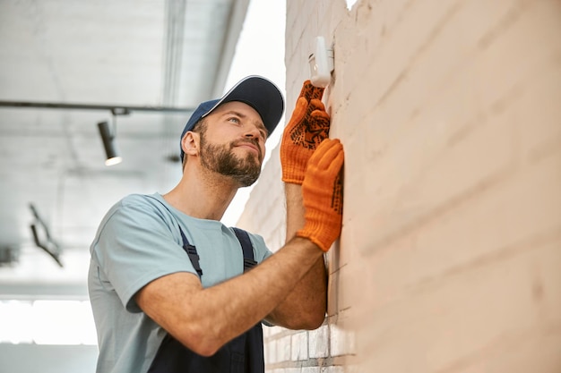 Bearded man checking security camera on the wall