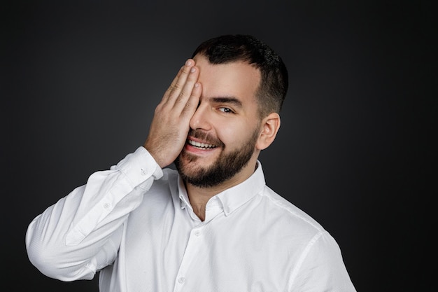 Bearded man closes his eyes with hand