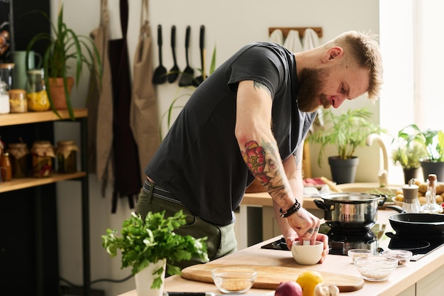 Bearded Man Crushing Spices At Kitchen