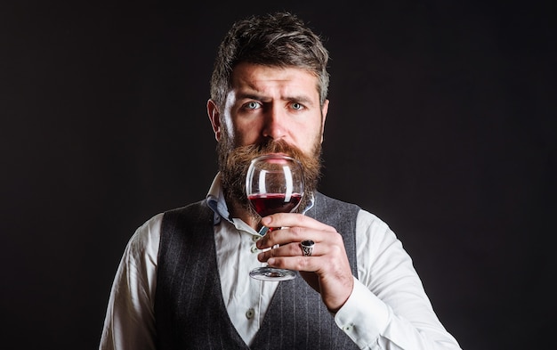 Bearded man Drinking red wine. Sommelier tasting wine in restaurant. Wine glass. Alcohol.