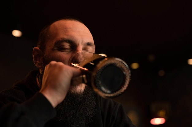 Bearded man holds glass of beer while sitting in pub Beer time Alcohol drinks