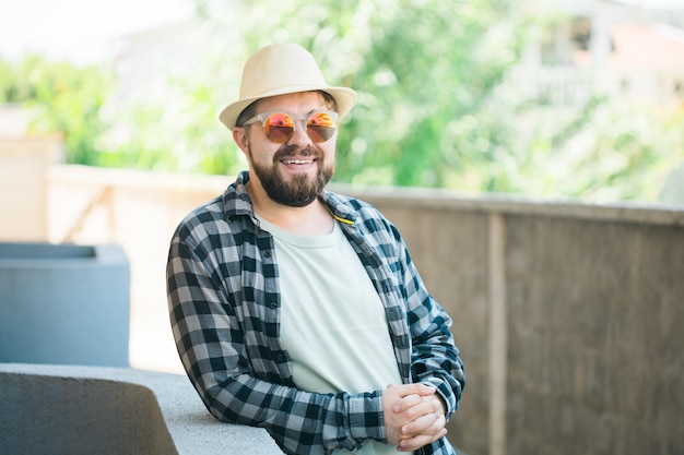 Bearded man portrait in summer clothes and hat stand over street city urban and travel concept